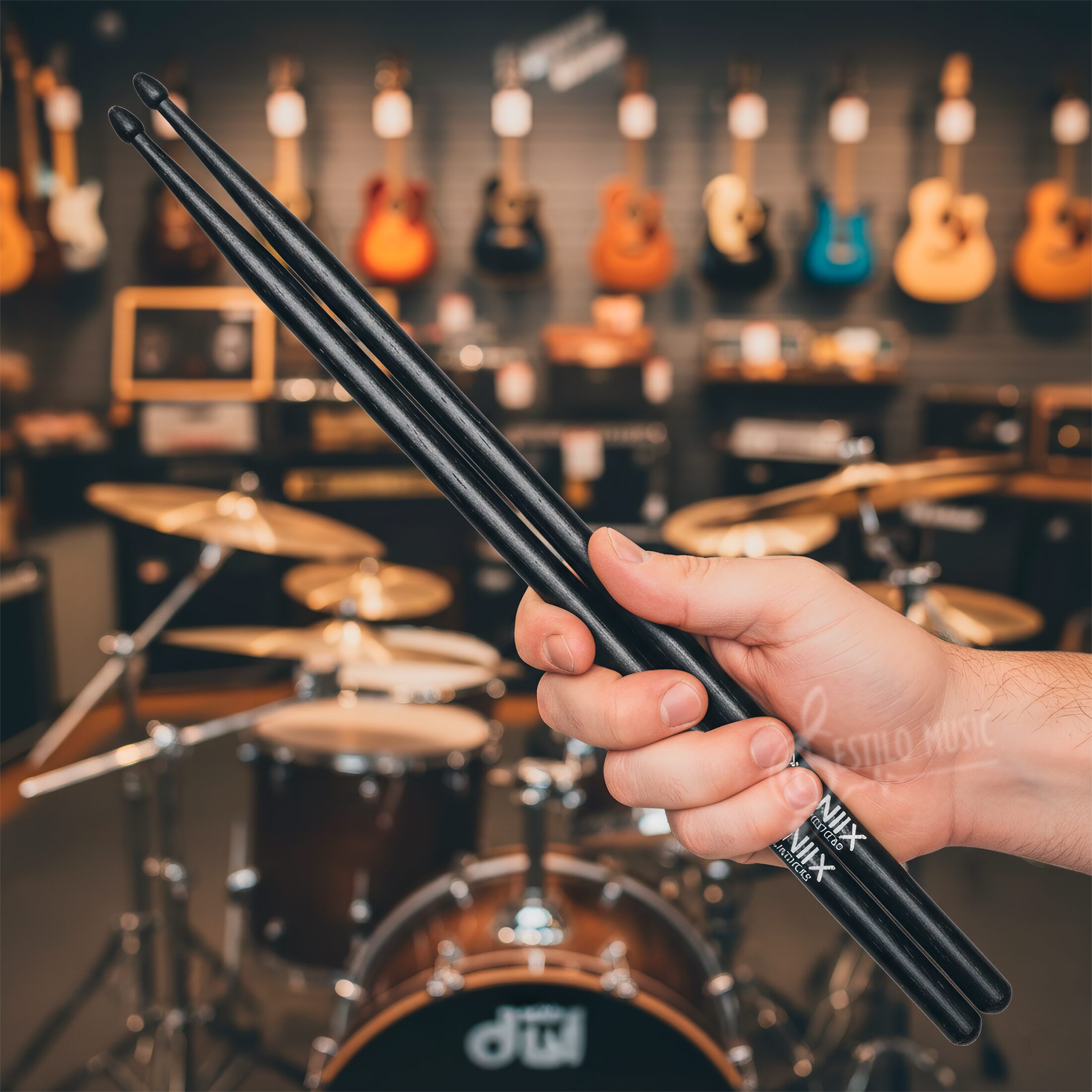 Baqueta Oniix Vic Firth utilizada sobre caja o platillo de batería, demostrando agarre firme, punta de lágrima afinada y resistencia de nogal americano para estilos de rock.