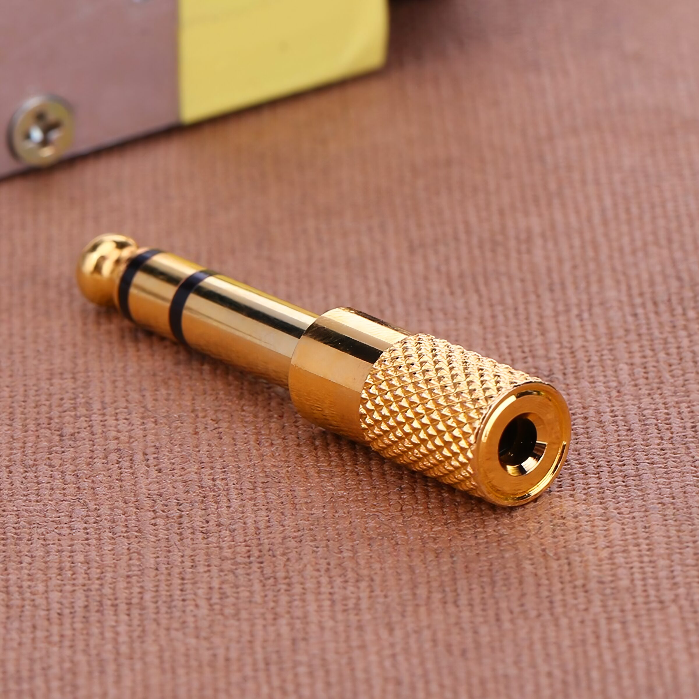 Adaptador de audio estéreo 6.5 mm macho a 3.5 mm hembra tipo plug auxiliar, carcasa metálica con aislante negro, ideal para conectar audífonos o cables auxiliares en amplificadores y equipos de sonido AA36